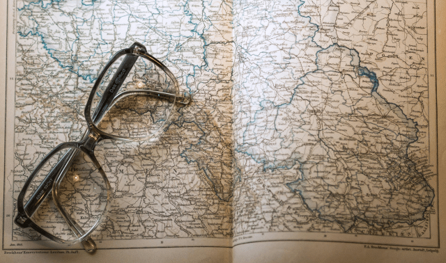 Image of eye glasses on top of an open atlas