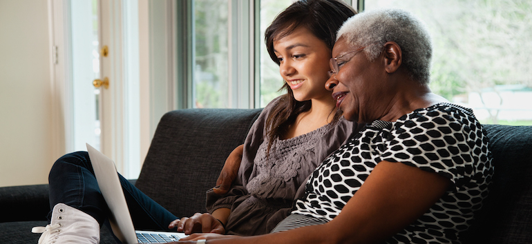 Two women researching on a laptop.