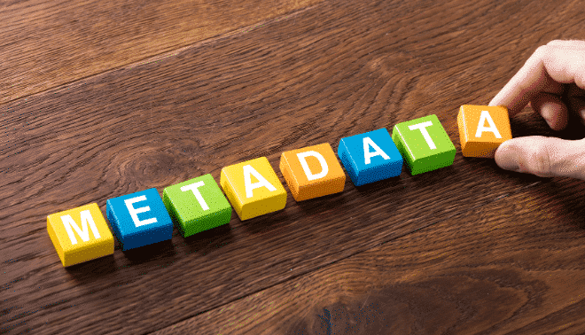 The word "metadata" spelled in colorful tiles on a wooden surface.