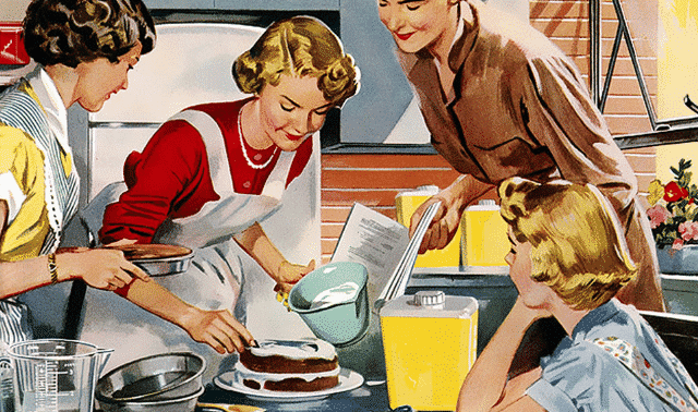 Four women in a kitchen gather around a table, preparing a cake. One is icing the cake while another pours a liquid. Two women watch while holding a measuring cup and a recipe book.