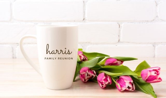 White souvenir mug with "Harris Family Reunion" on it sitting next to pink tulips