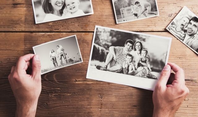 Woman holding black and white family photos about to start a family photo project