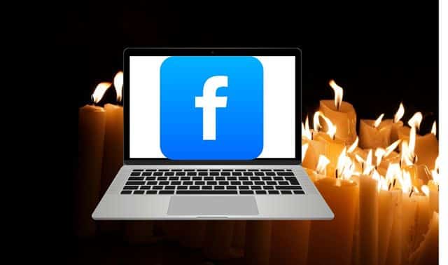 A laptop displaying the Facebook logo is set against a backdrop of lit candles in the dark.